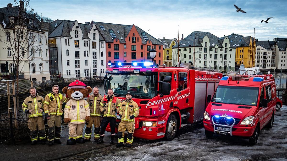 Brannkonstabler, maskot og brannbiler ved Brosundet i Ålesund - Klikk for stort bilde